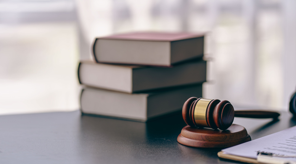 Judge's gavel with books and a clipboard on a desk