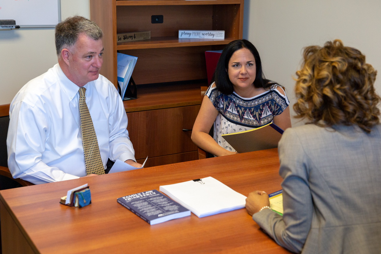 Couple Discussing with an Attorney